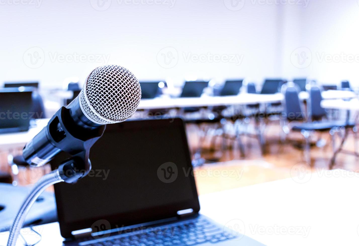 dichtbij omhoog microfoon met laptop Aan tafel achtergrond in congres kamer foto