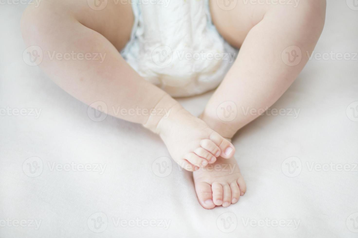 kleine babymeisje voeten op het bed foto