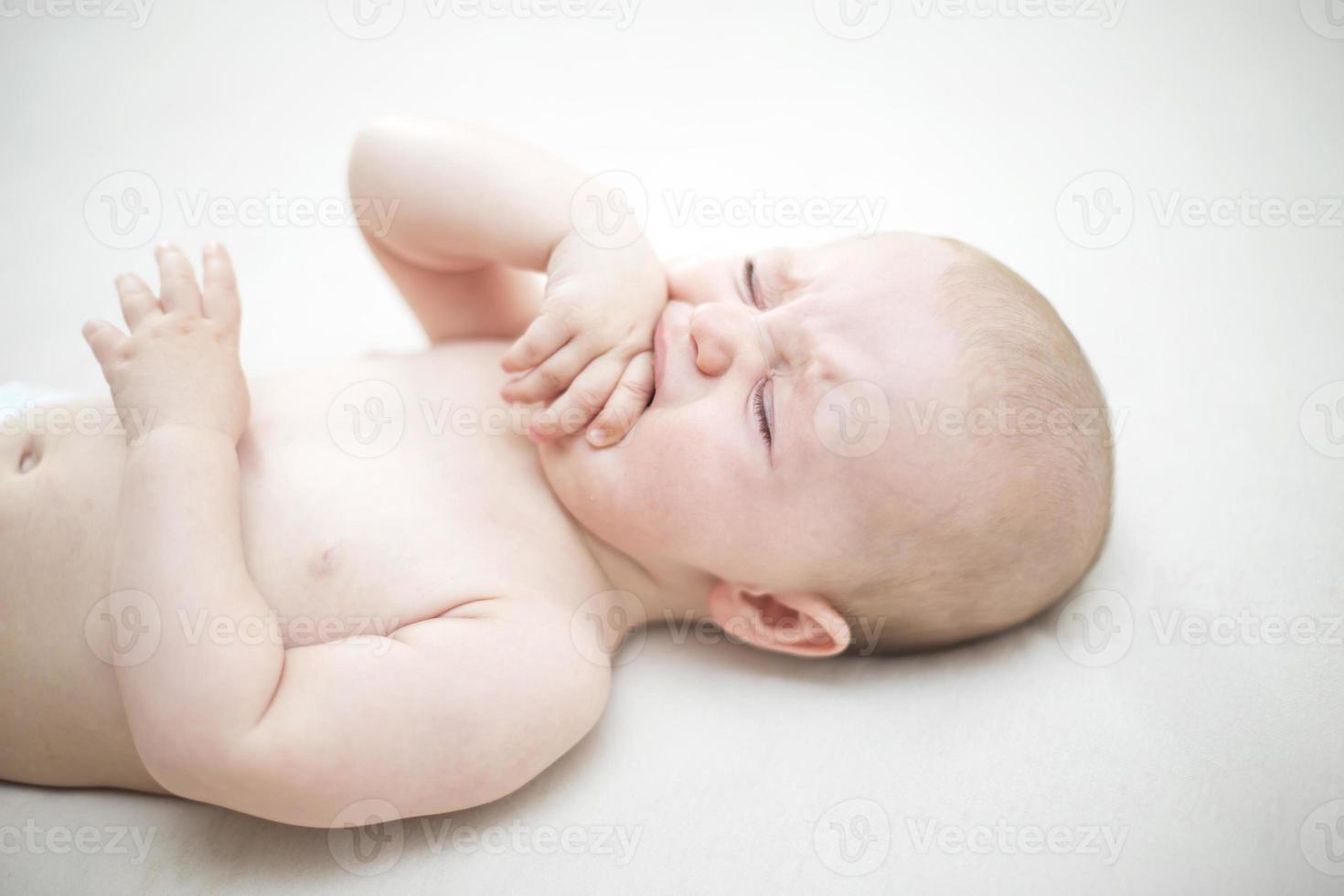 schattige babymeisje huilen op bed foto