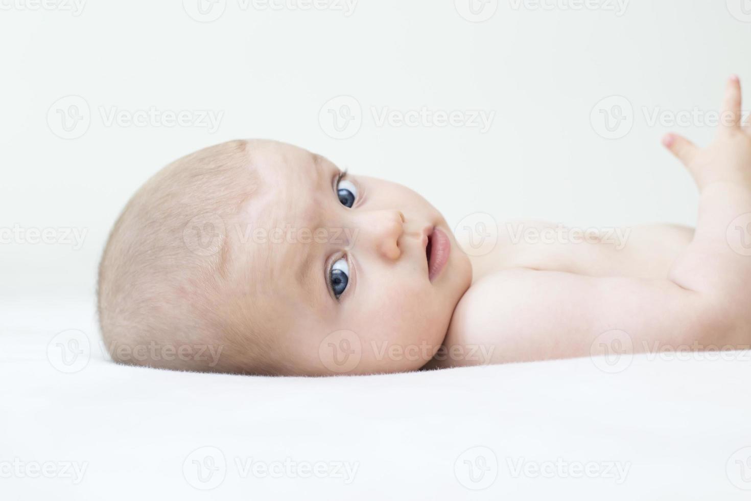 schattige babymeisje liggend op bed foto