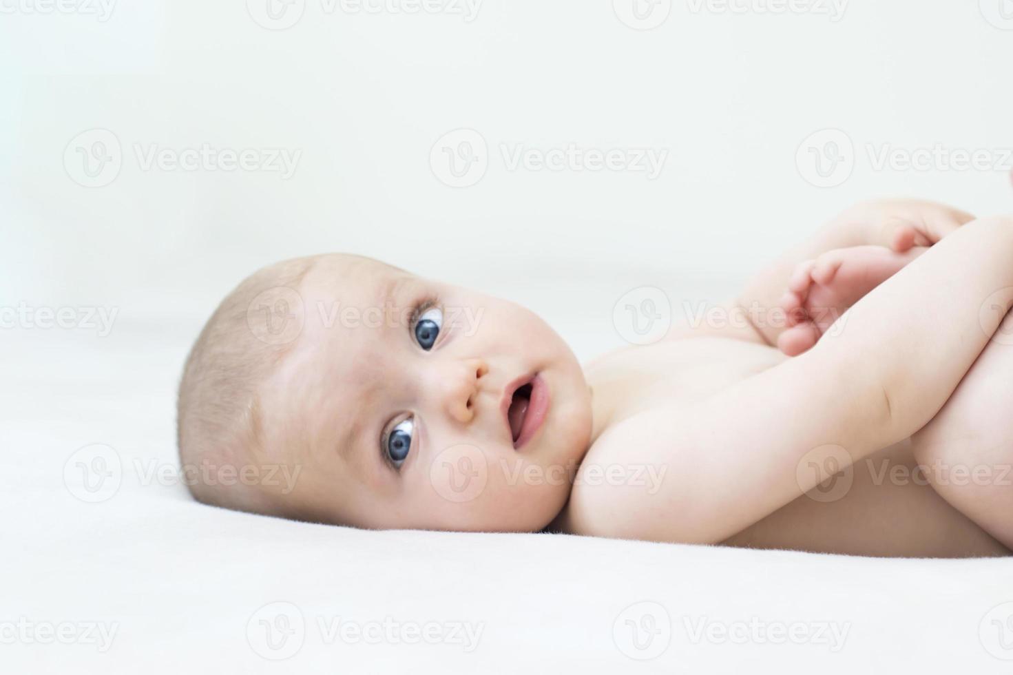 schattige babymeisje liggend op bed foto