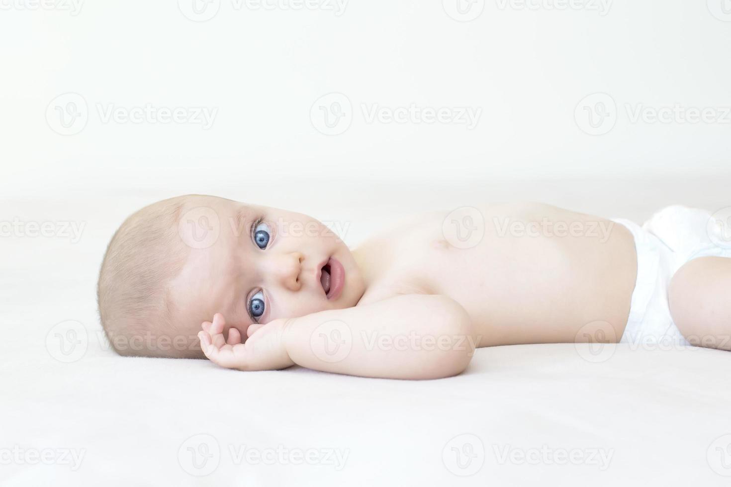 schattige babymeisje liggend op bed foto