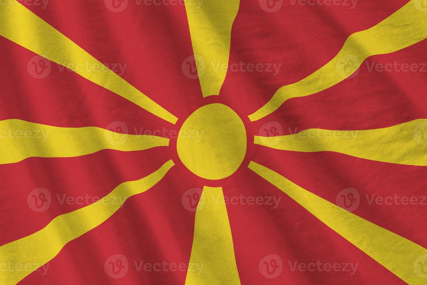 Macedonië vlag met groot vouwen golvend dichtbij omhoog onder de studio licht binnenshuis. de officieel symbolen en kleuren in banier foto