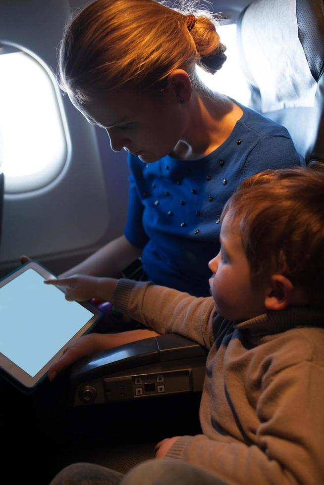 moeder en jongen die in een vliegtuig reizen foto