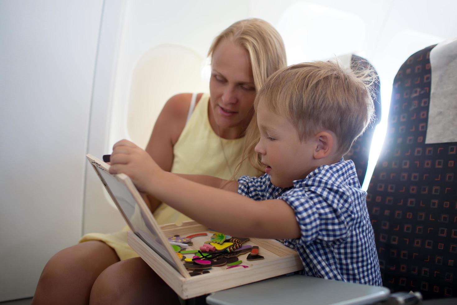 moeder en zoon spelen samen in een vliegtuig foto