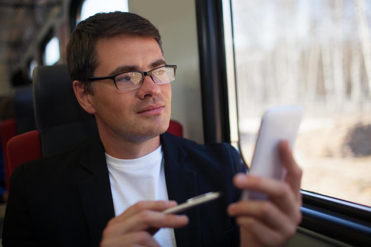 man met behulp van een telefoon in een trein foto