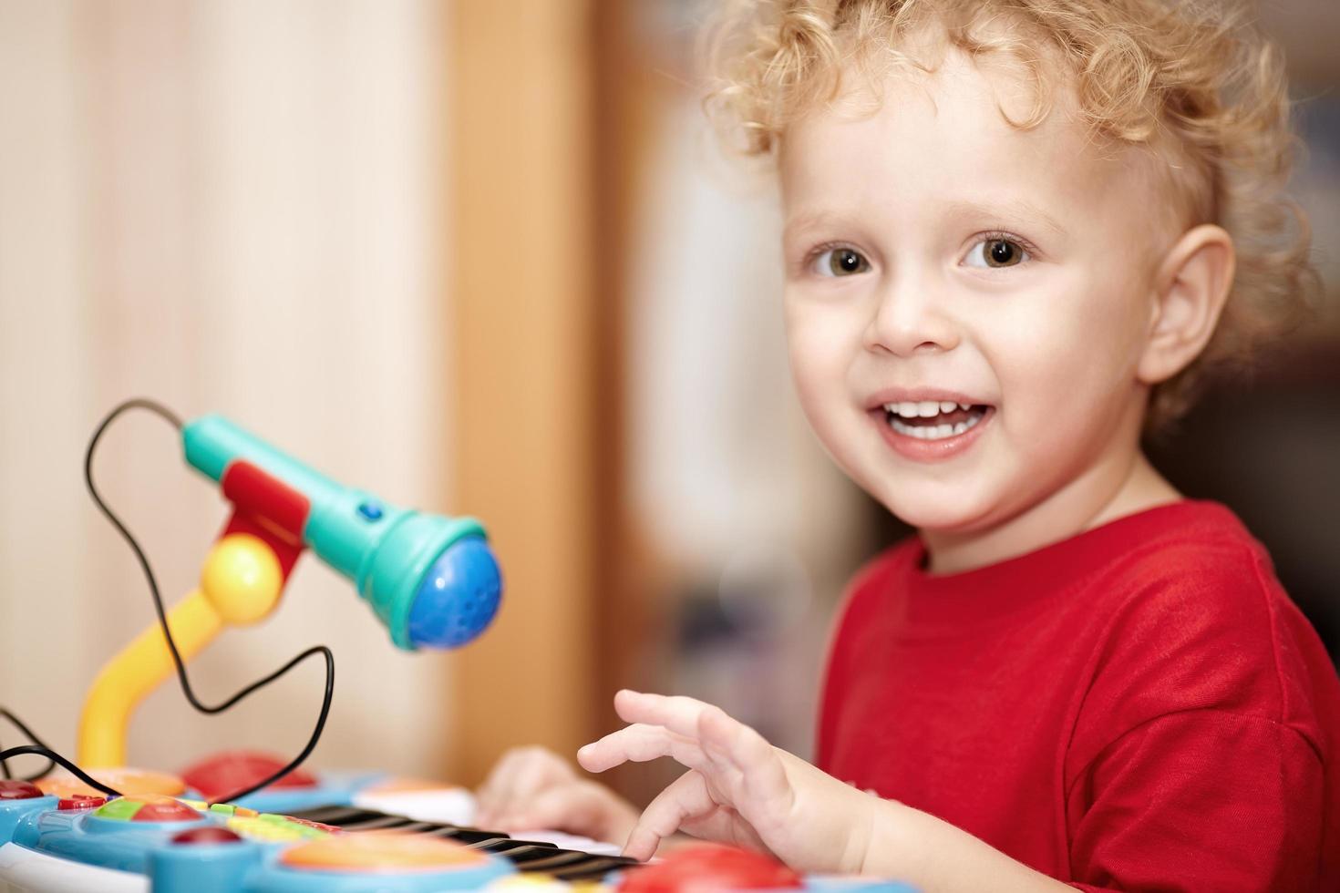 jongen speelt met een microfoon speelgoed foto