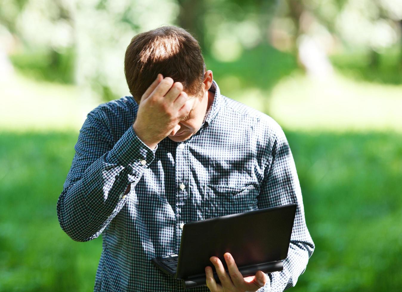 gefrustreerde man buiten met een laptop foto