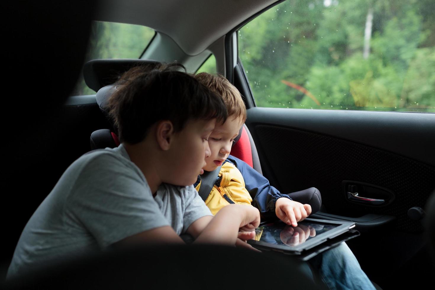 jongens die een tablet in een auto gebruiken foto