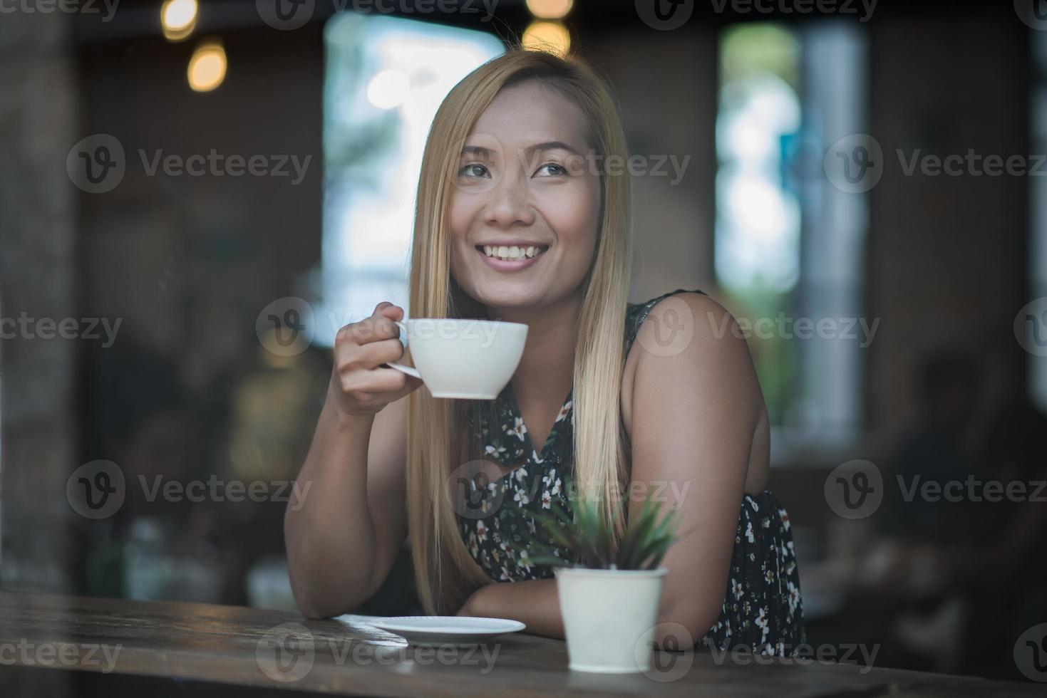 mooie vrouw in een café koffie drinken foto