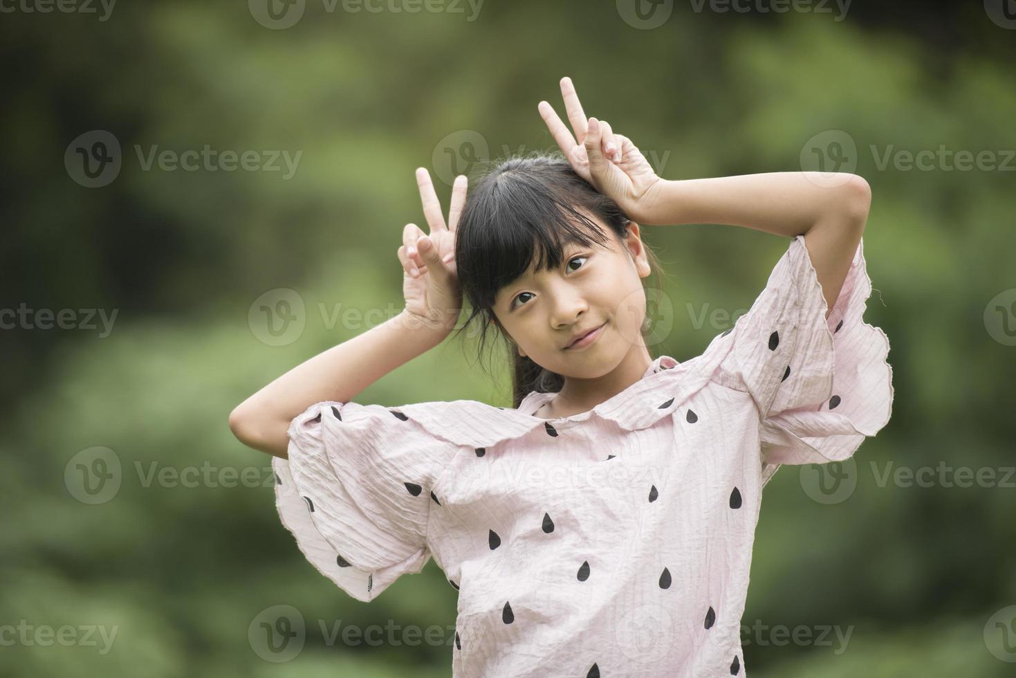 portret van een klein Aziatisch meisje wordt speels met de camera foto