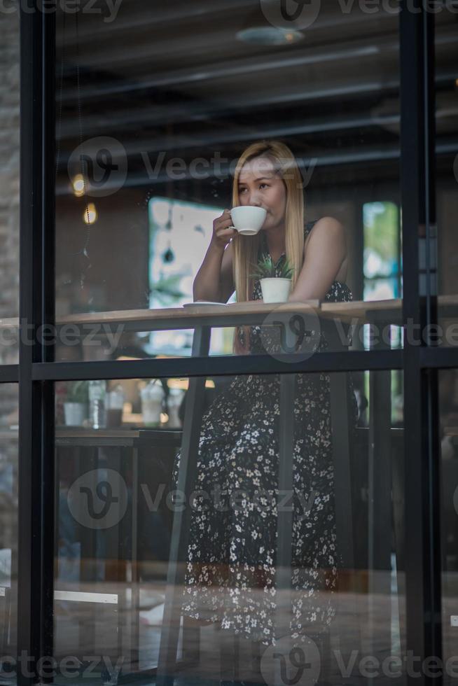 mooie vrouw in een café koffie drinken foto