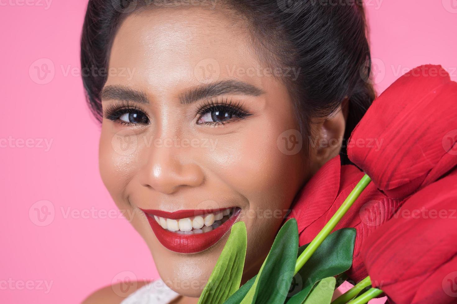 portret van een mooie vrouw met een boeket van rode tulp bloemen foto