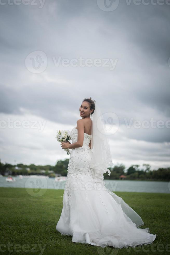 mooie bruid met bloemen, bruiloft make-up en kapsel foto