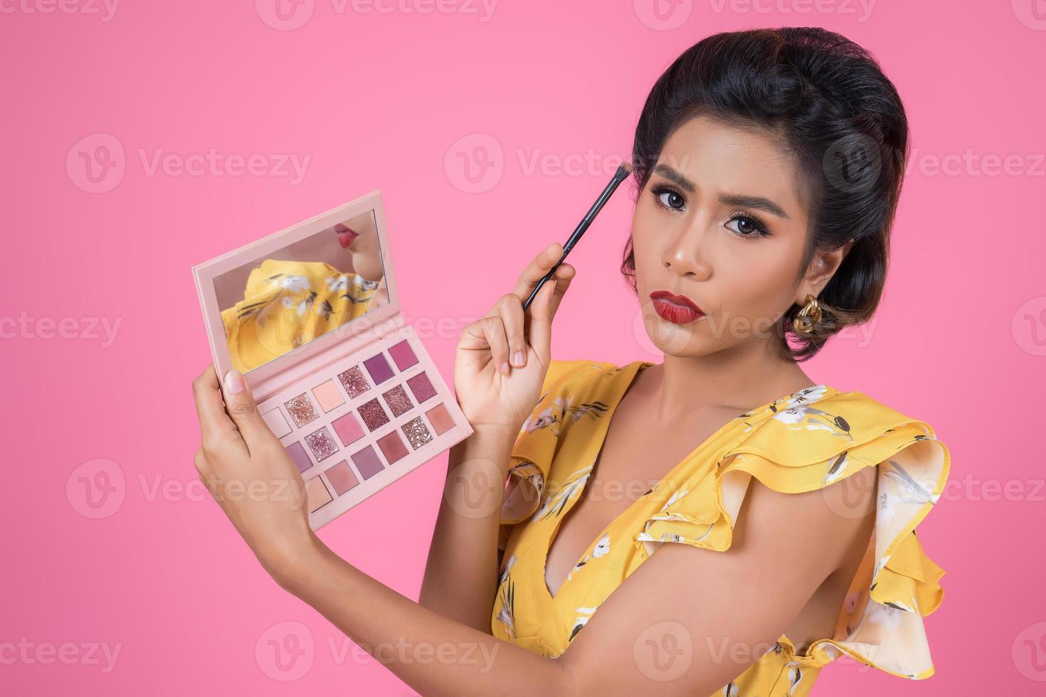 portret van een vrouw met make-up en cosmetische borstel foto