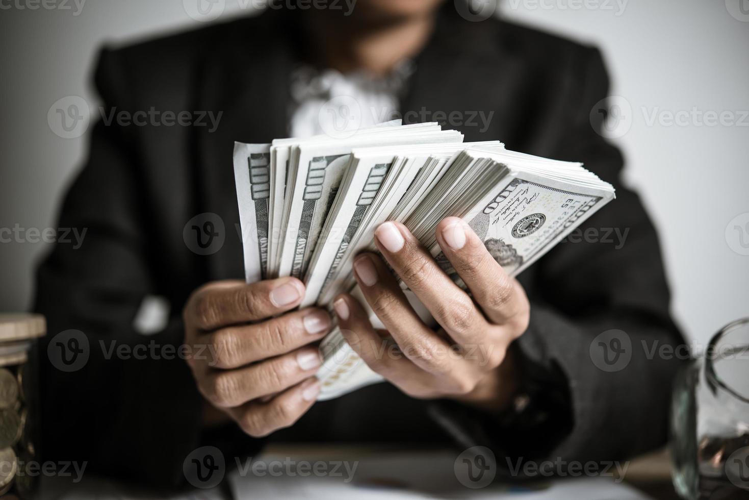 close-up handen van een zakenvrouw dollarbiljetten te houden foto