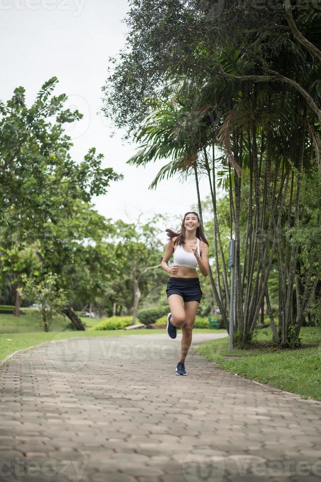 jonge sportieve vrouw die bij het park loopt foto