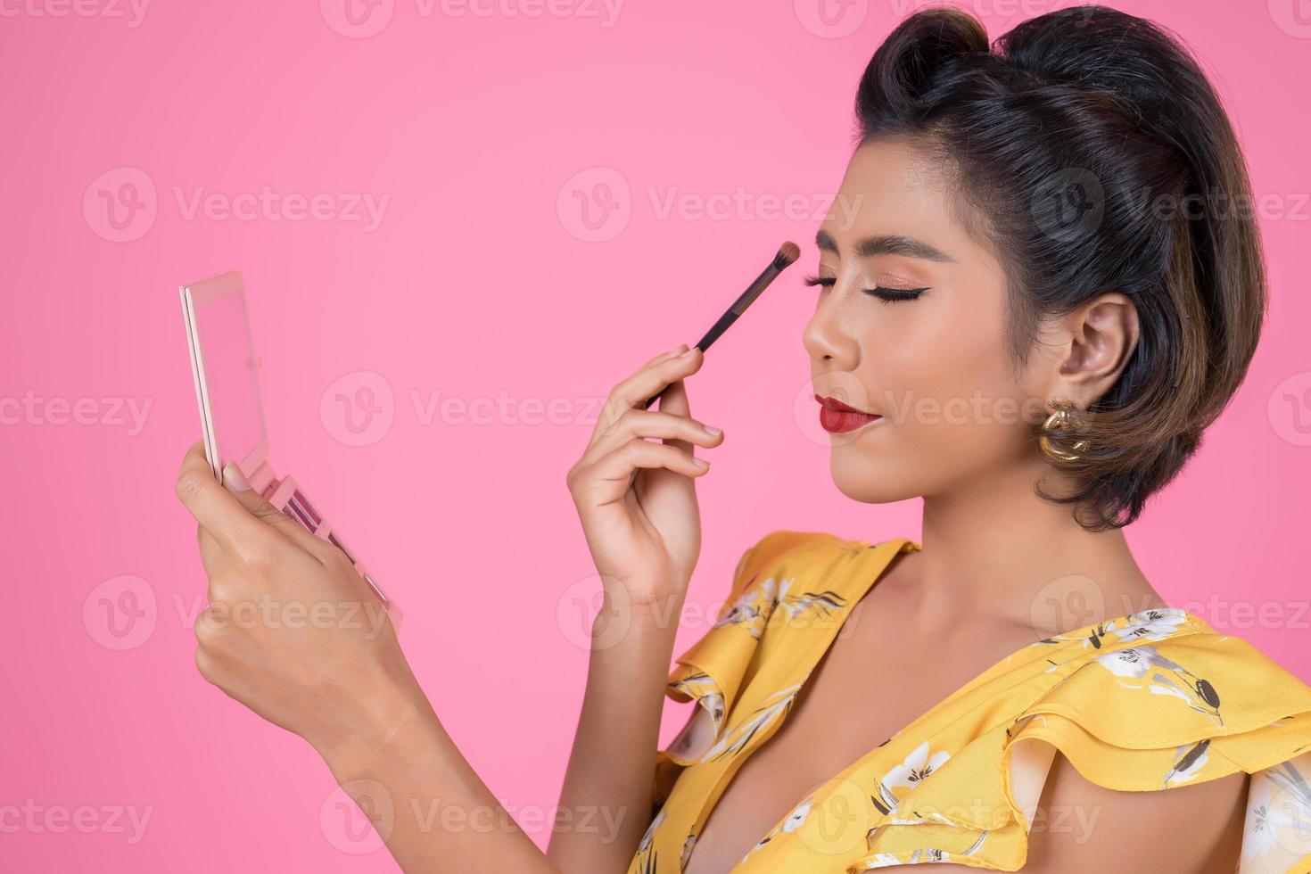 portret van een vrouw met make-up en cosmetische borstel foto