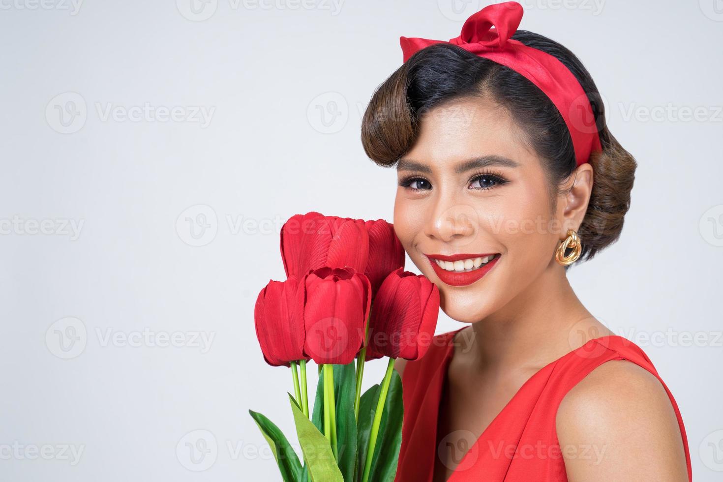 portret van een mooie vrouw met een boeket van rode tulp bloemen foto