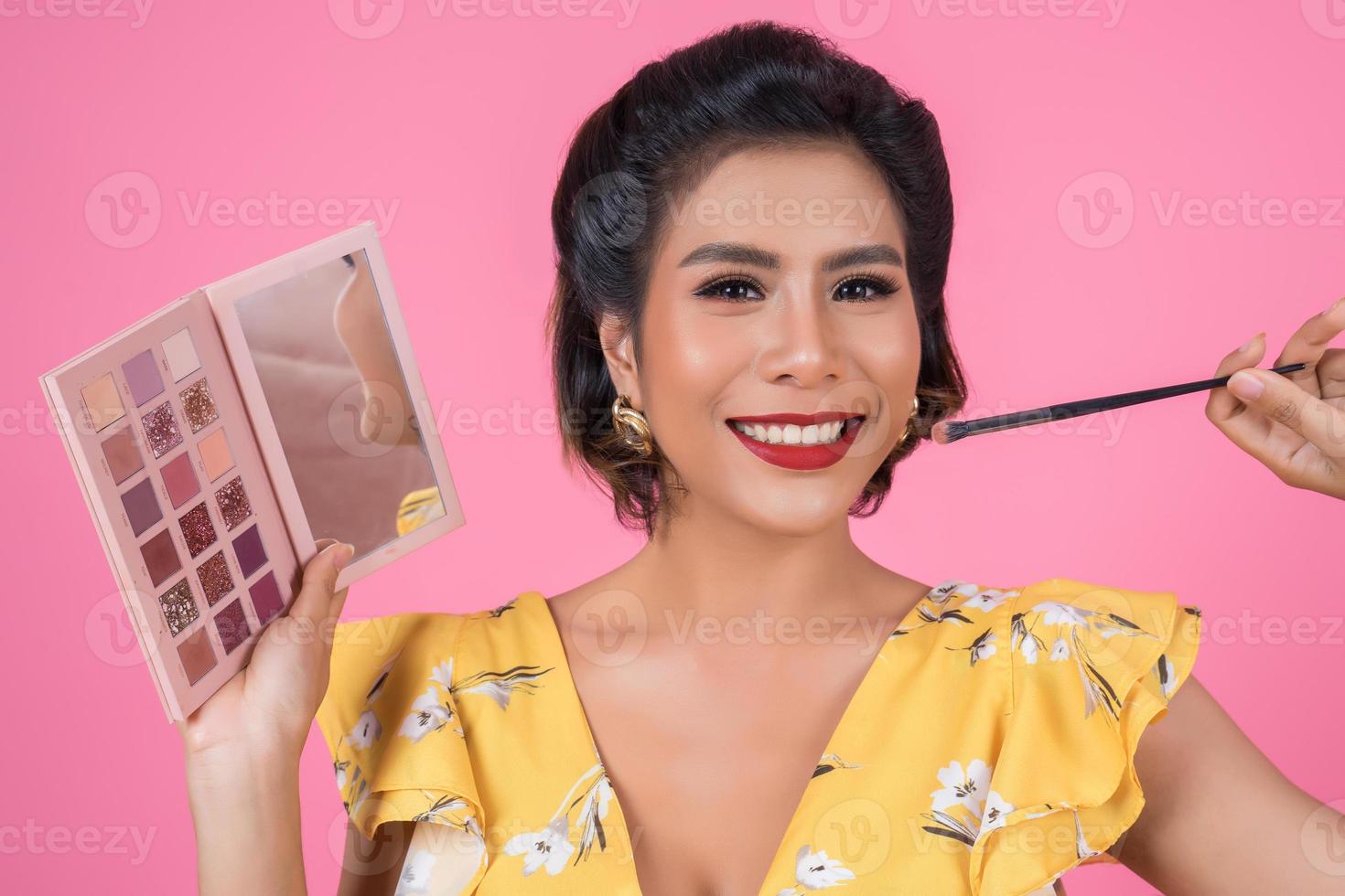 portret van een vrouw met make-up en cosmetische borstel foto