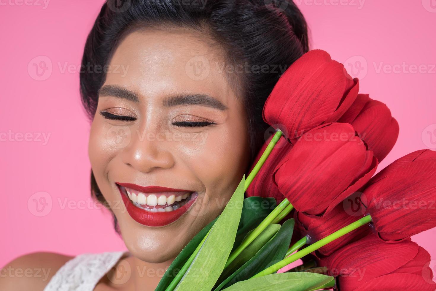 portret van een mooie vrouw met een boeket van rode tulp bloemen foto