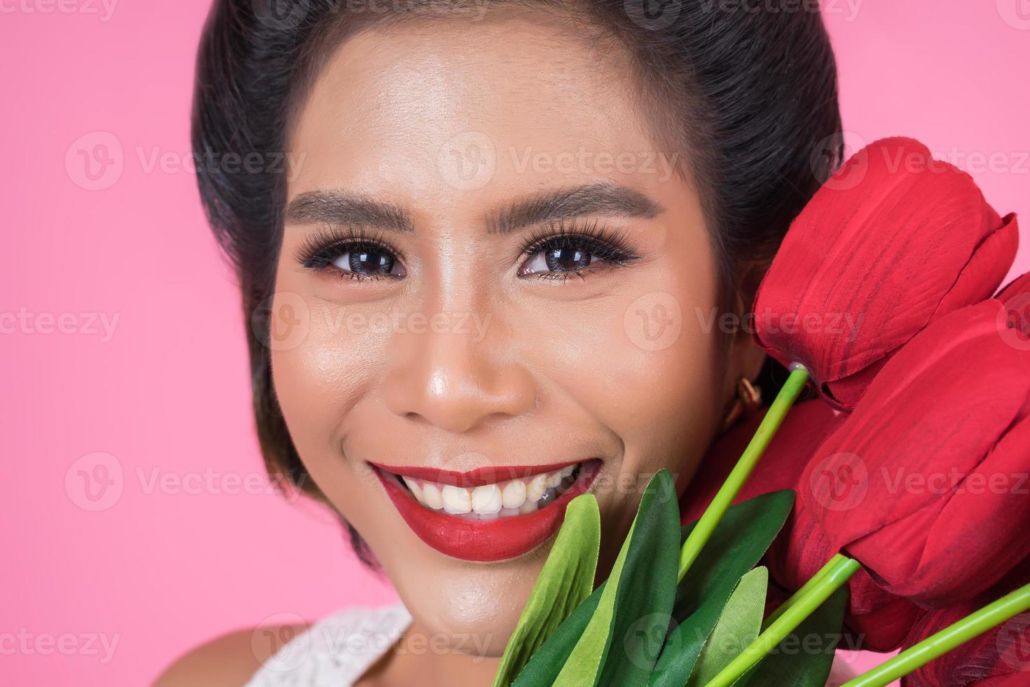 portret van een mooie vrouw met een boeket van rode tulp bloemen foto