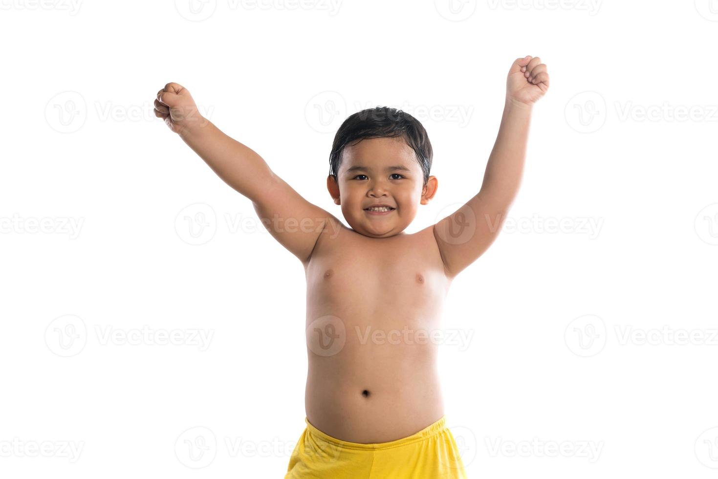 grappige kleine jongen die zijn biceps-spieren toont die op witte achtergrond worden geïsoleerd foto
