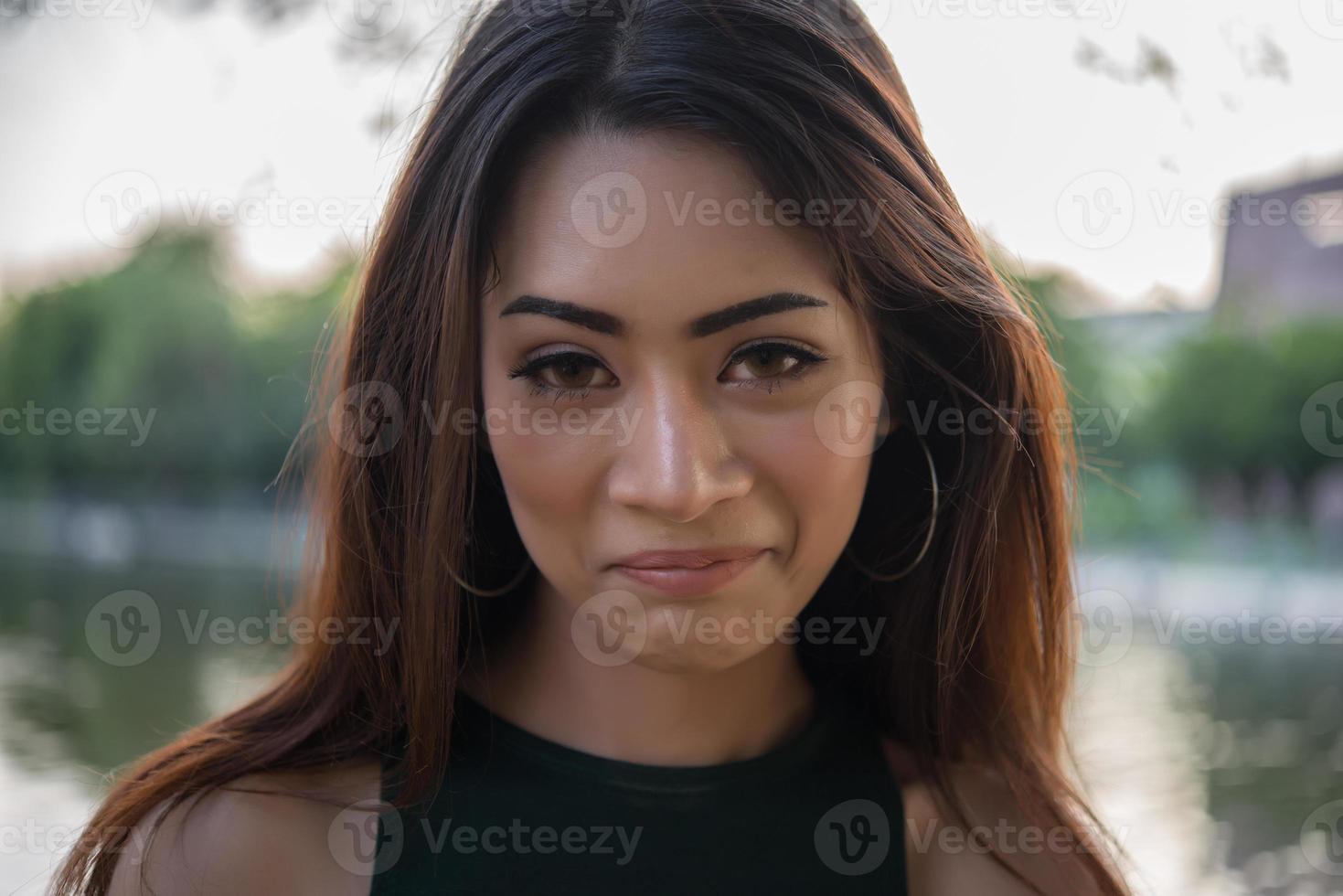 portret van een lachend meisje ontspannen in een natuurpark buitenshuis foto