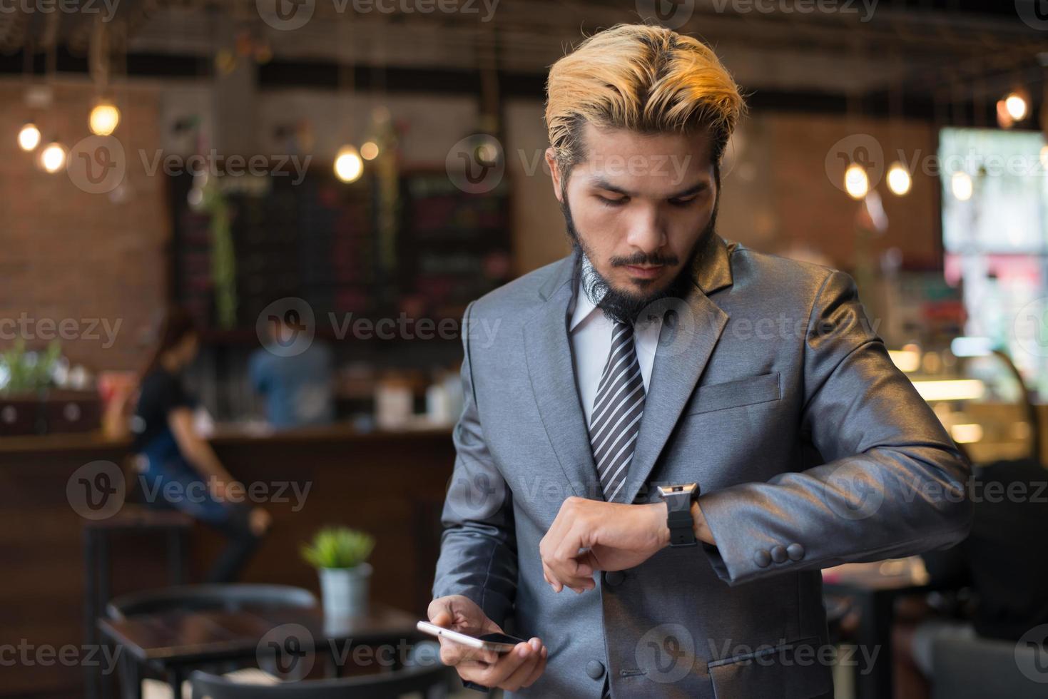 zakenman praten over telefoon kijken hand horloge foto