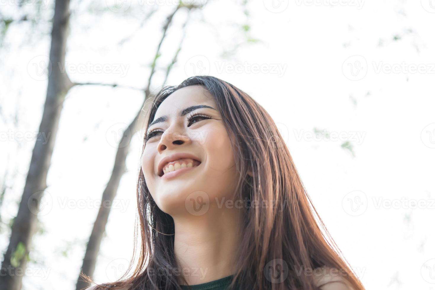 portret van een lachend meisje ontspannen in een natuurpark buitenshuis foto