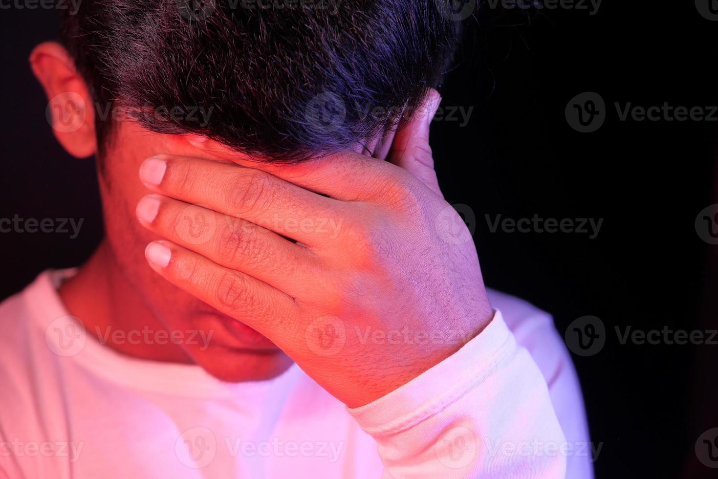 close-up van trieste man die betrekking hebben op gezicht met de hand foto