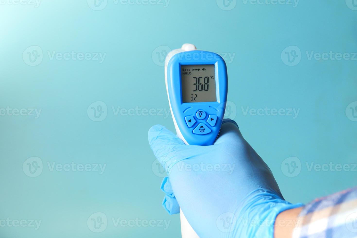 hand met infrarood thermometer voor het meten van temperatuur foto