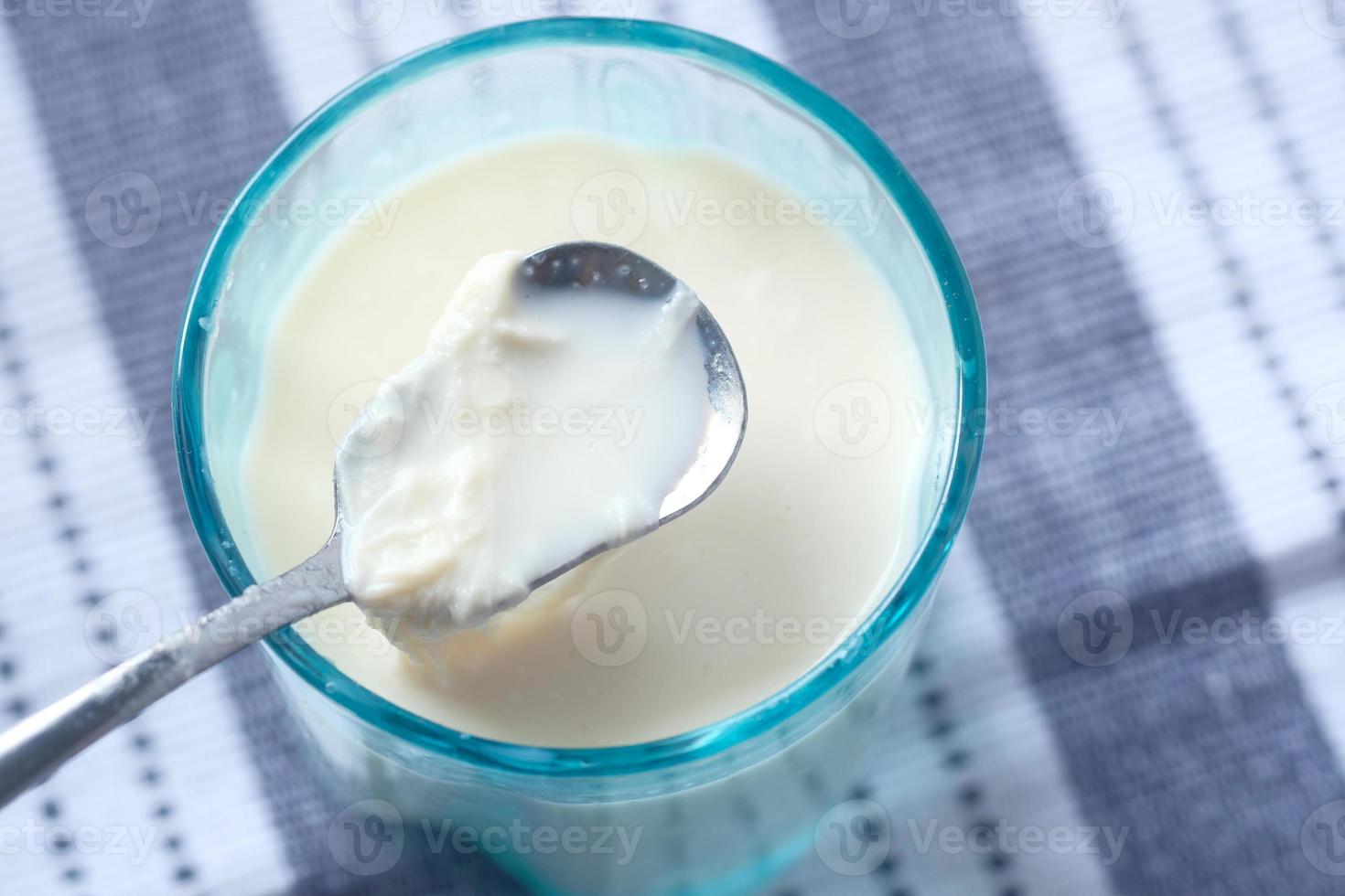 close-up van glas melk en lepel op tafel foto