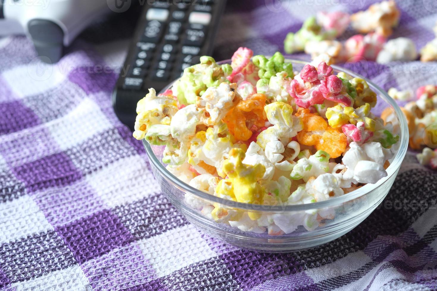 hoge hoekmening van popcorn en tv-afstandsbediening op tafel foto