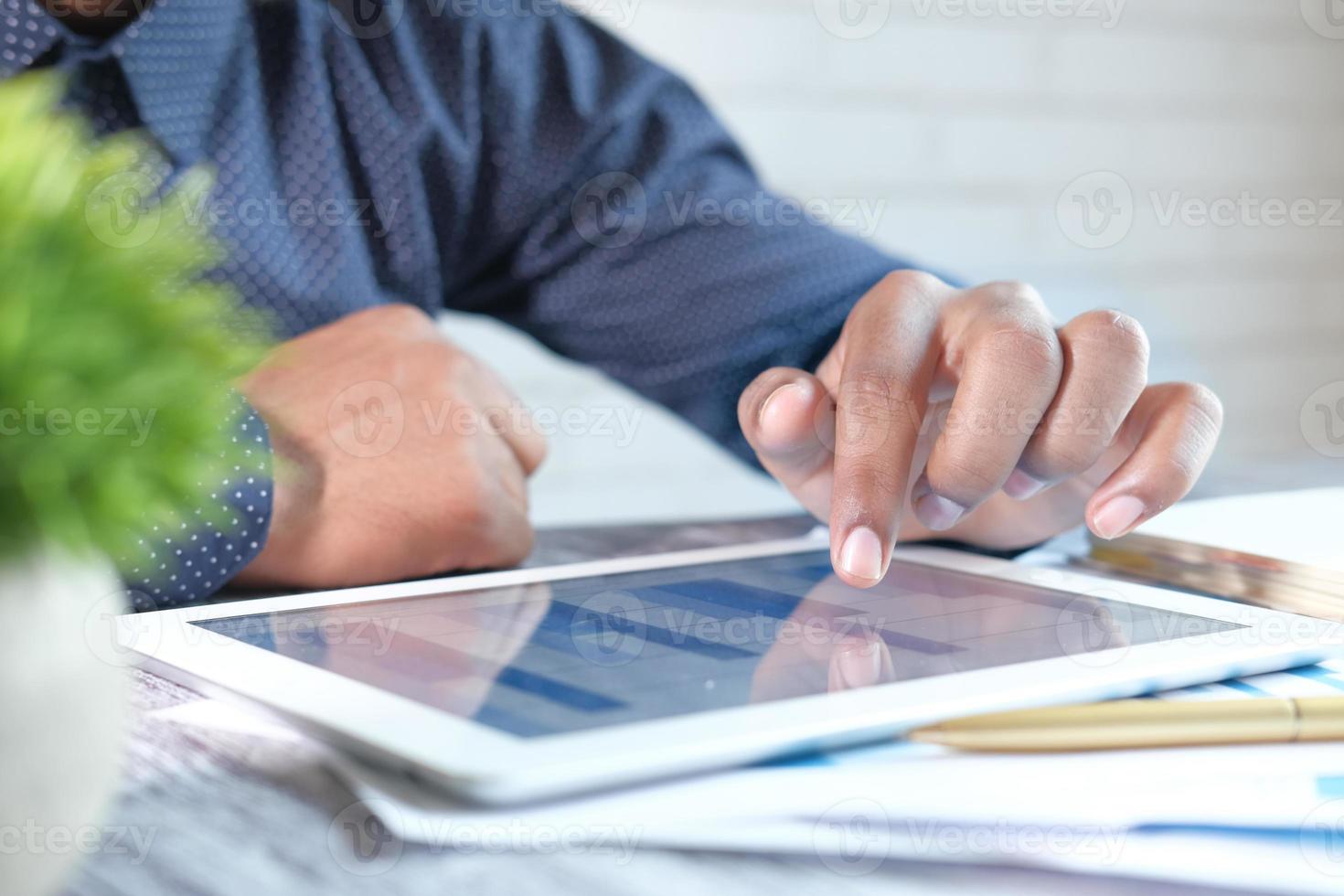 jonge man analyseren financiële diagram op digitale tablet foto