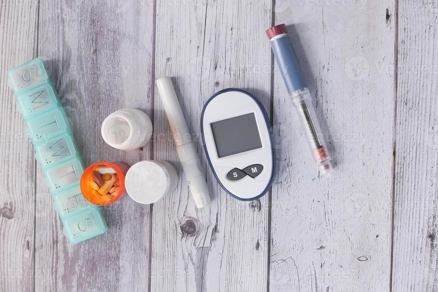 bovenaanzicht van diabetische meetinstrumenten en pillen op kleur achtergrond foto