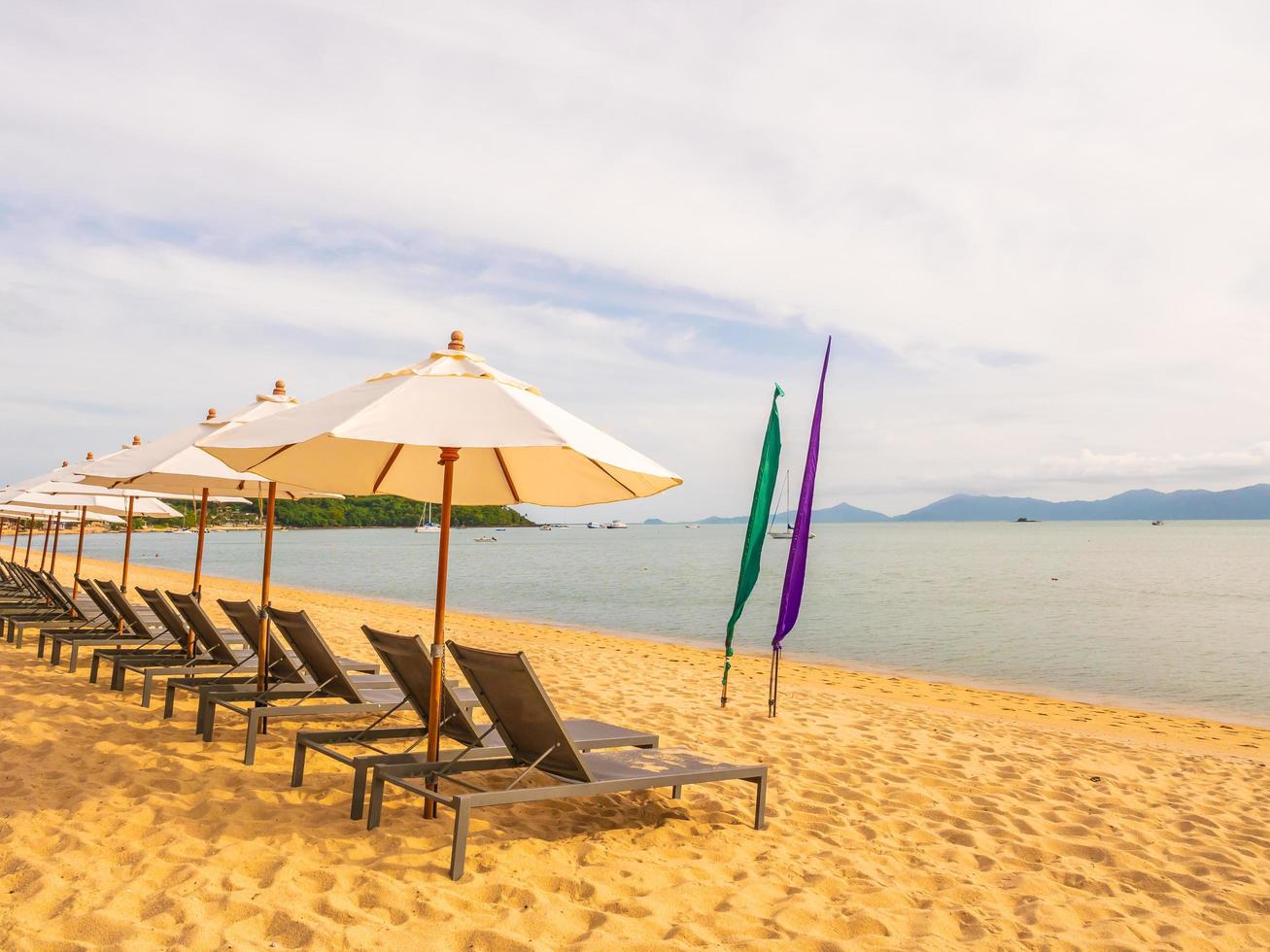 parasols en ligbedden op het tropische strand foto