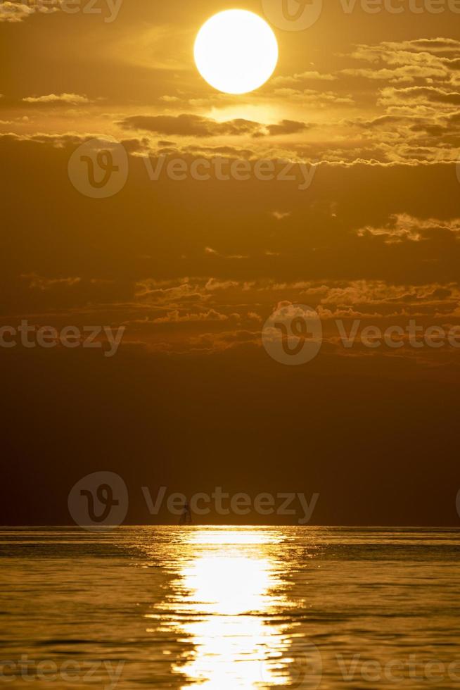 klein zeilboot Bij zonsondergang foto