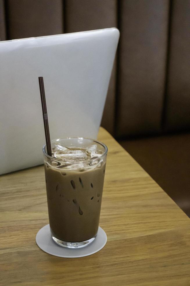 ijskoffie drinken op houten tafel met laptop foto
