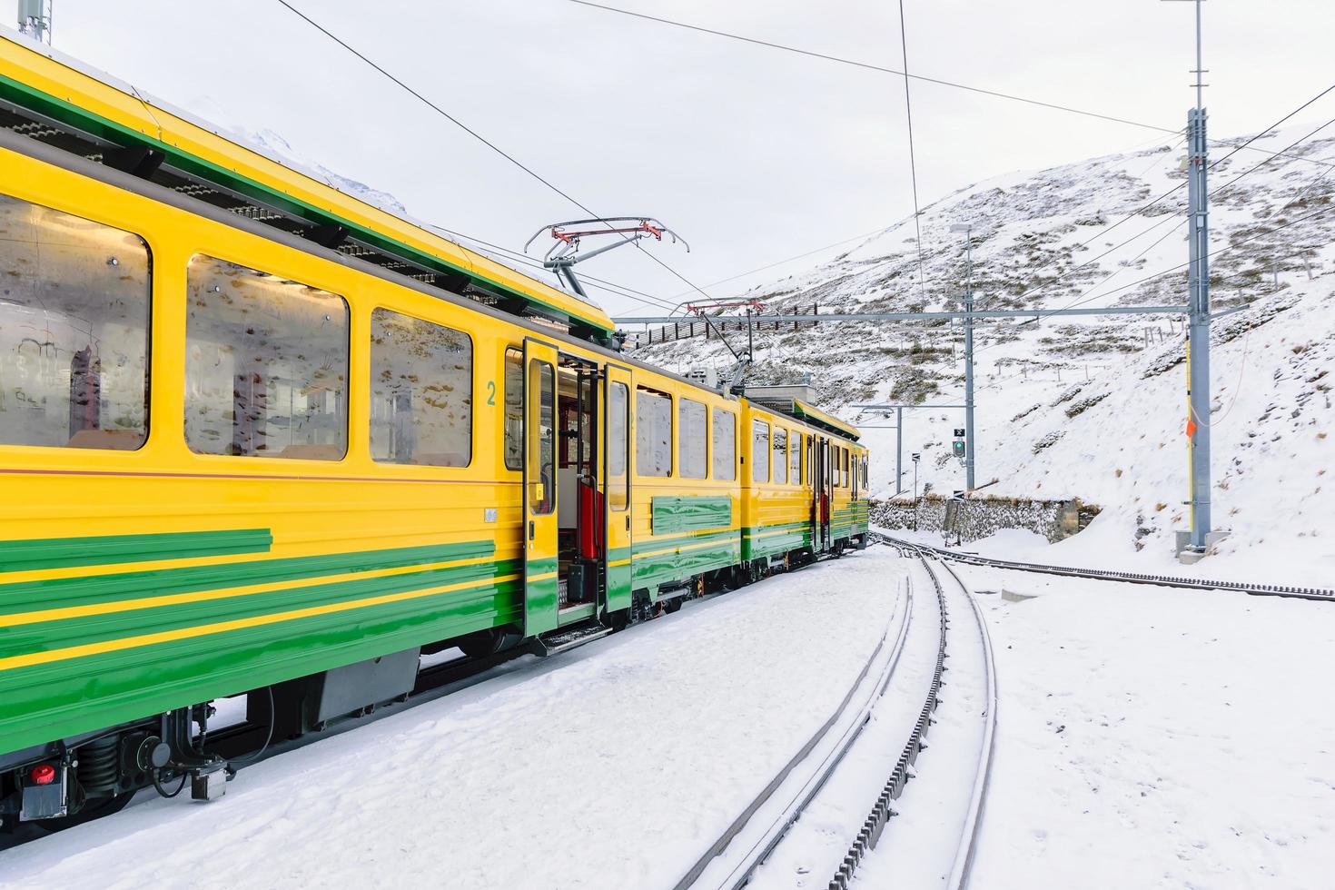 treinauto's op de jungfrau-spoorweg tegen besneeuwde bergen in zwitserland foto