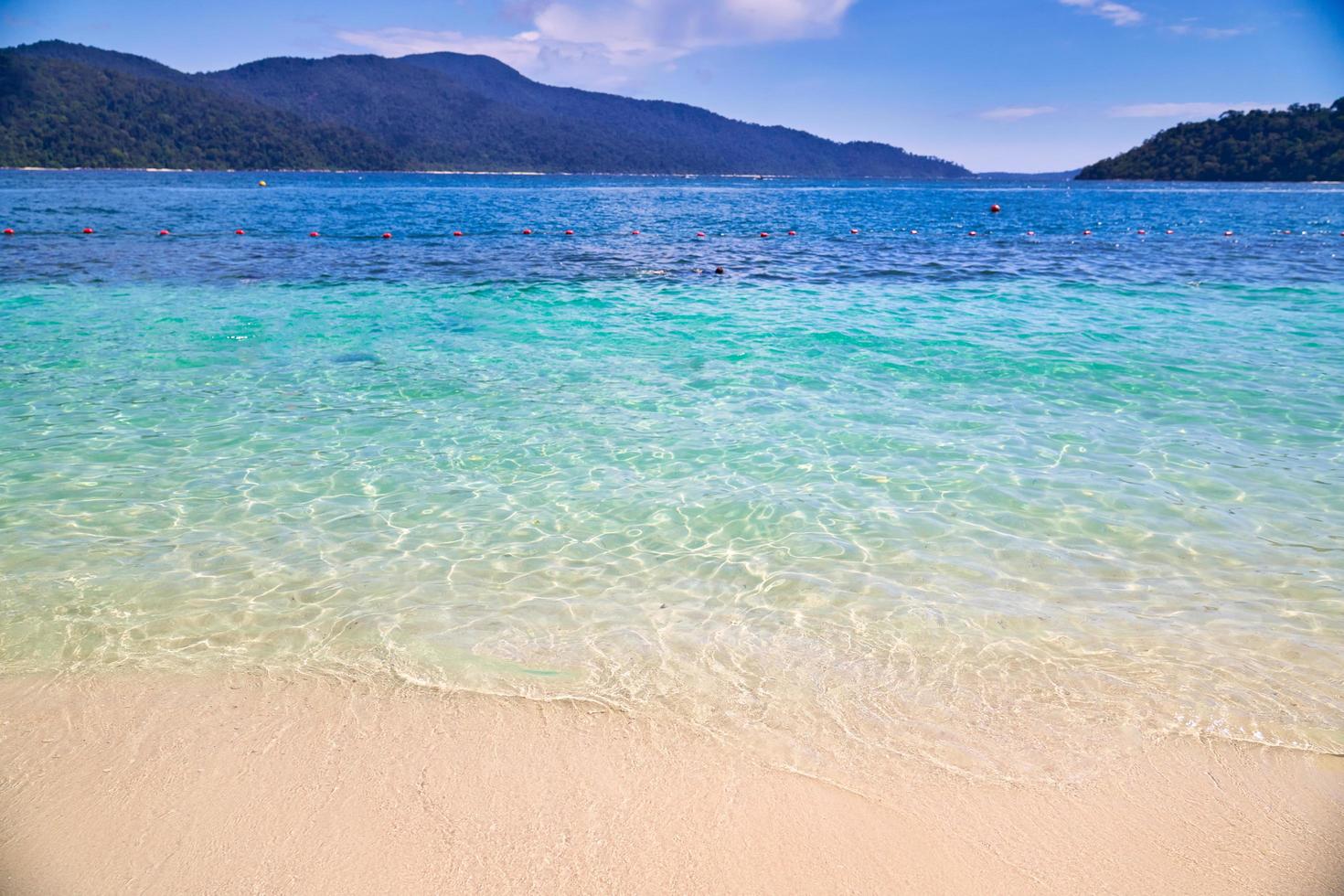 golven, blauw water en bergen met bewolkte blauwe hemel bij een strand bij Koh Lipe-eiland in Thailand foto