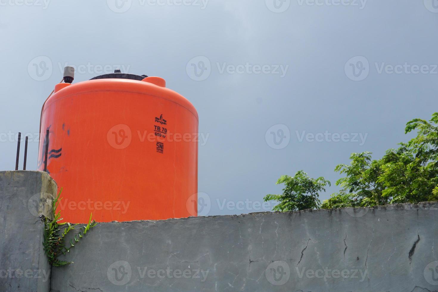 groot oranje water reservoir Aan de dak van de huis. foto