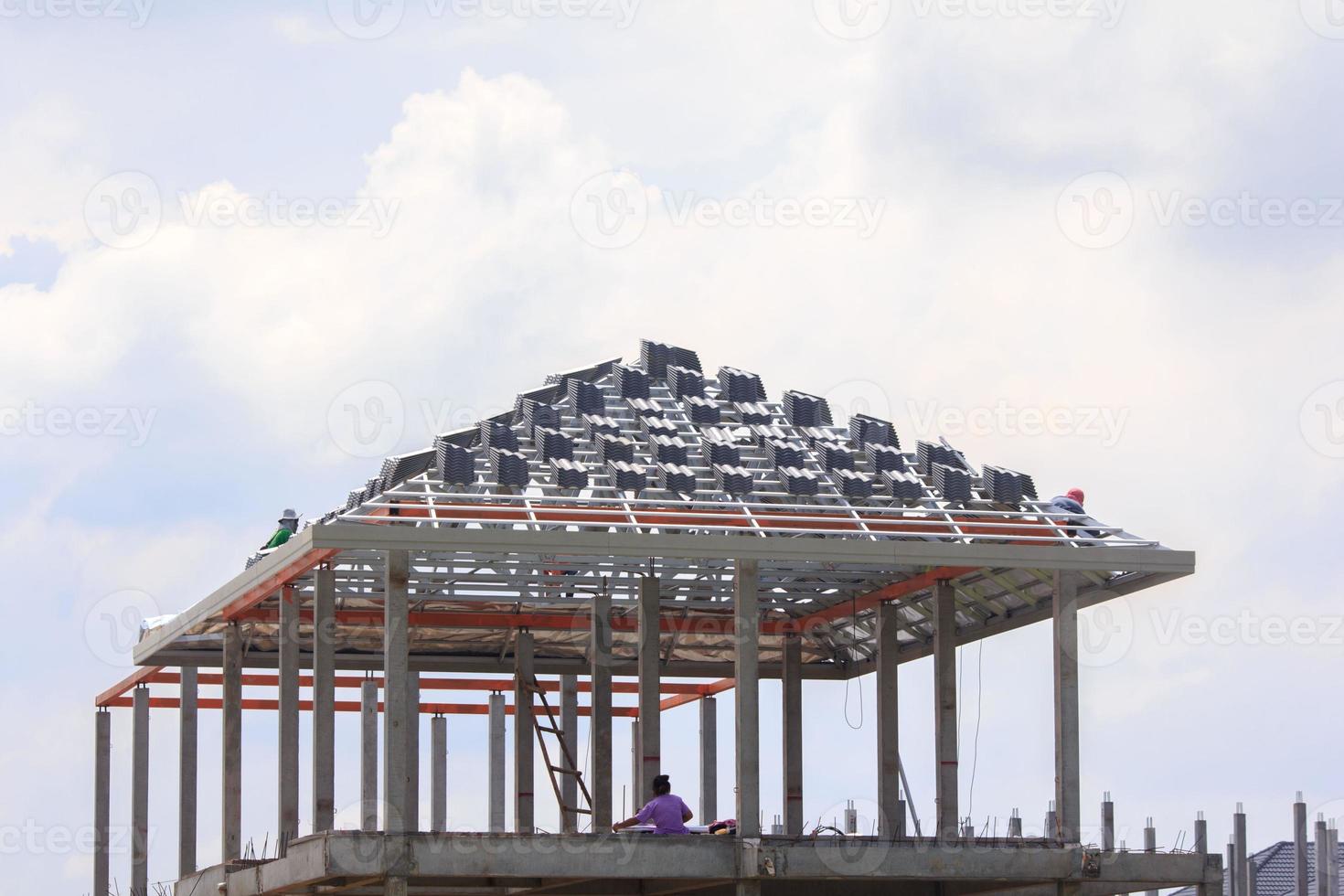 bouw van een huis met een dik staal kader en dakbedekking tegels voor zon en regen bescherming door geschoold ambachtslieden wie werk Bij hoogten vereist: precisie en extreem voorzichtigheid - Spaans stijl - foto