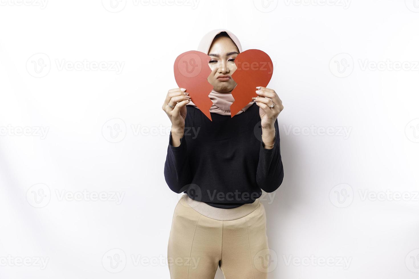 mooi jong Aziatisch moslim vrouw uitgedrukt haar droefheid terwijl Holding gebroken hart geïsoleerd Aan wit achtergrond foto