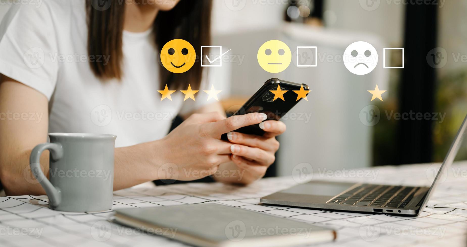 klant onderhoud evaluatie concept. zakenvrouw drukken gezicht glimlach emoticon tonen Aan virtueel scherm Bij tablet en smartphone in kantoor foto