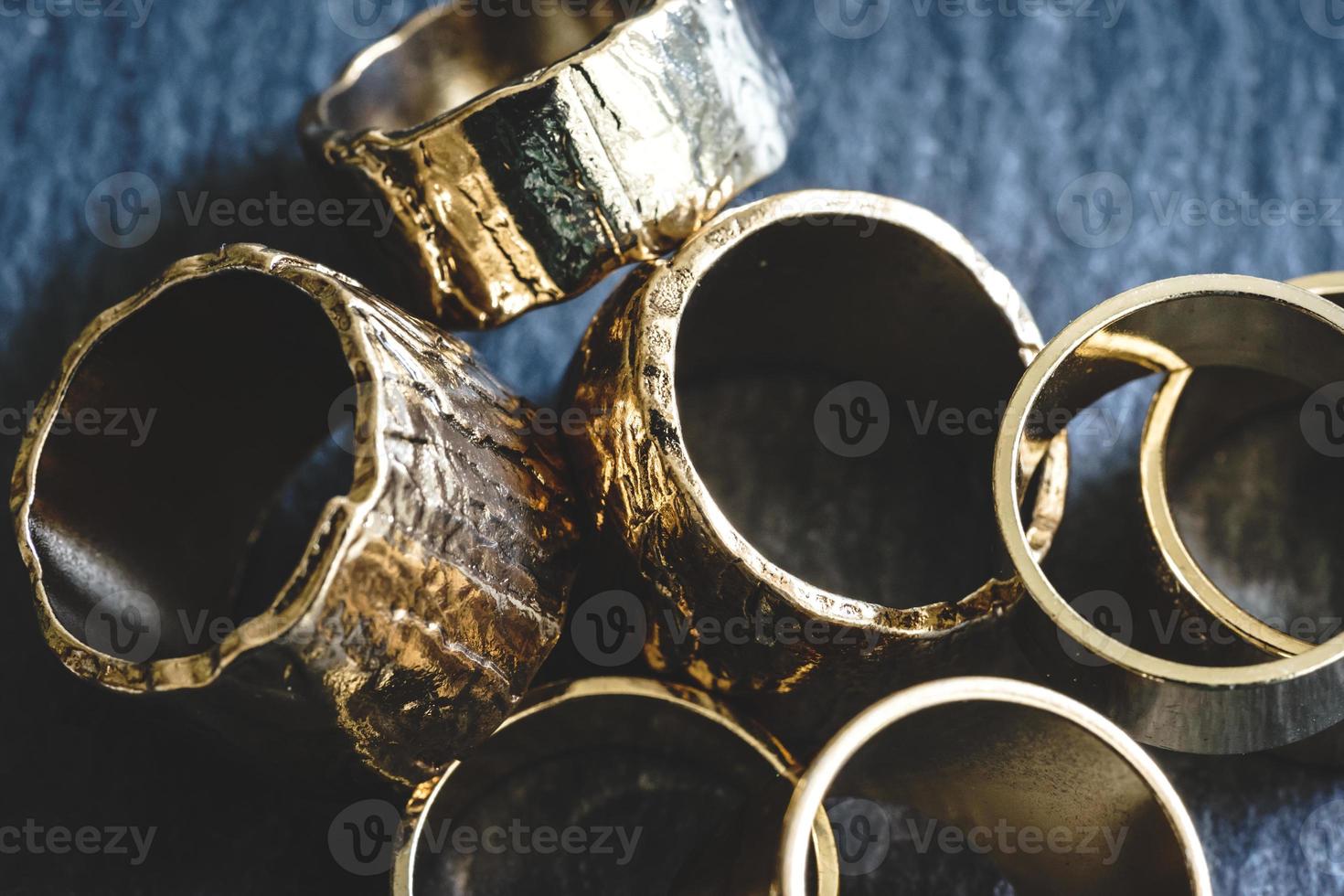 verschillende gouden ringen opgestapeld op een leistenen bord foto