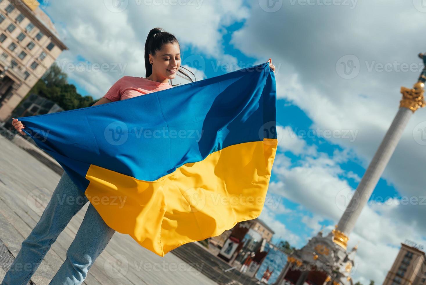 jong vrouw met nationaal vlag van Oekraïne Aan de straat foto