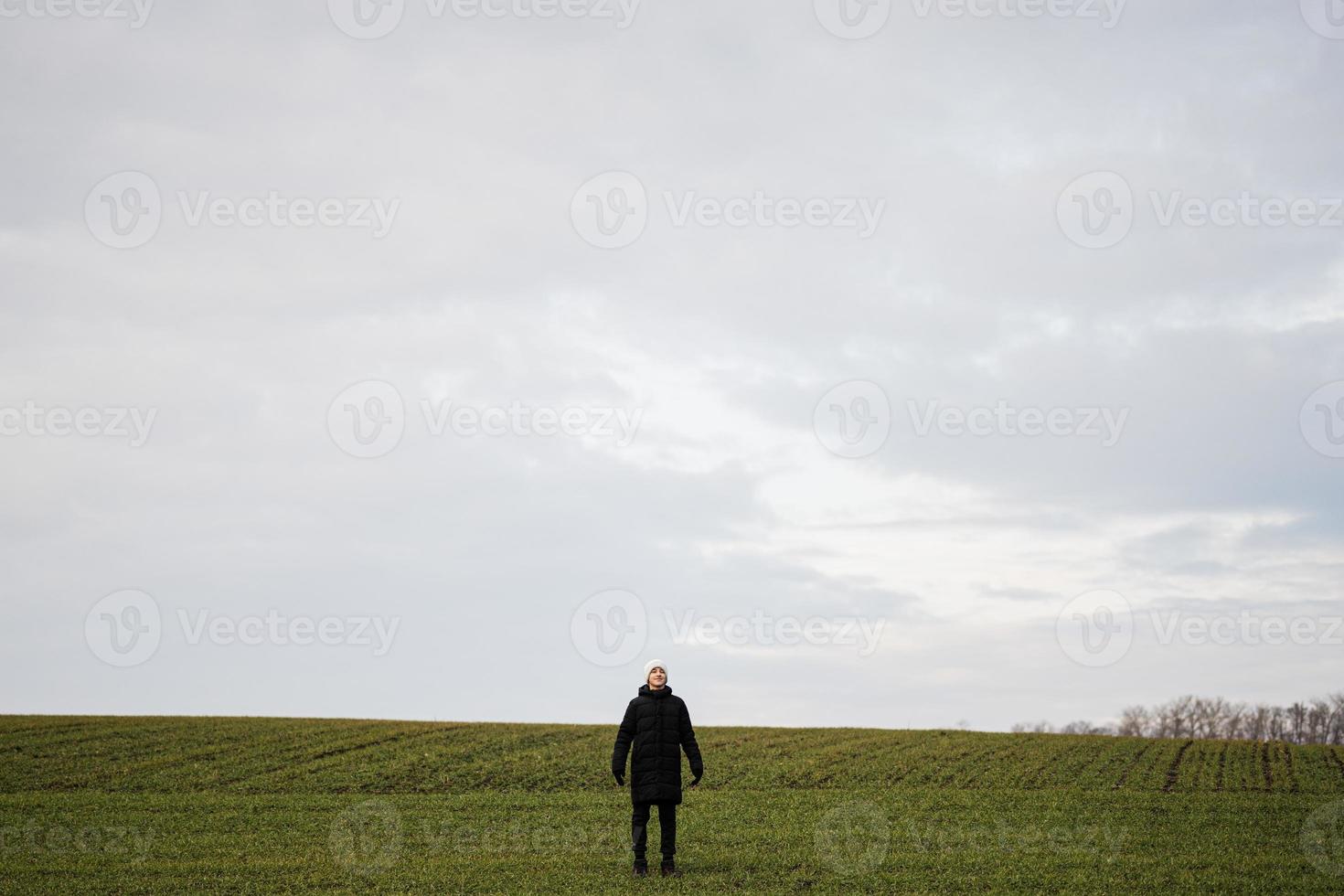 tiener jongen vervelend zwart jasje en wit hoed buiten, geniet in de vroeg voorjaar veld.. foto