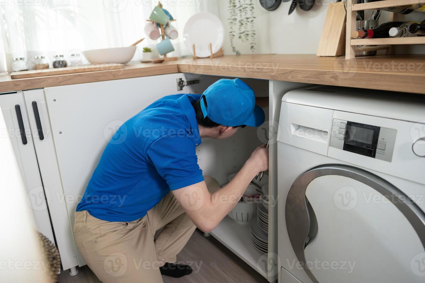 een Aziatisch jong technicus onderhoud Mens vervelend blauw uniform controle elektrisch huishoudelijke apparaten in huis foto