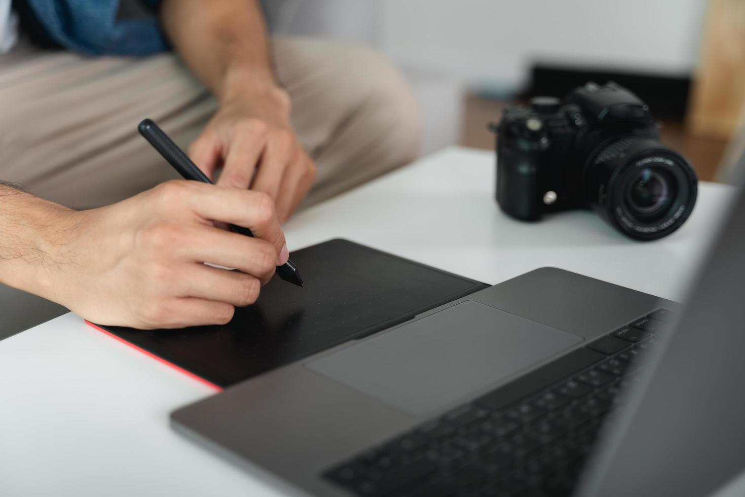 Mens ontwerper gebruik makend van pen muis tablet tekening en schrijven Aan tablet bord met stylus voor retoucheren, en grafisch ontwerp. foto